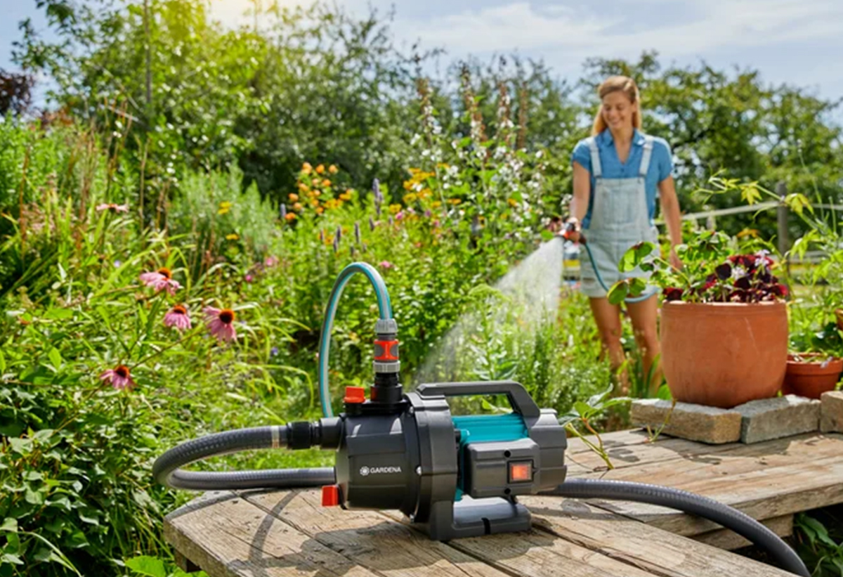 Απεικονίζεται μια γυναίκα να χρησιμοποιεί το πιεστικό για να ποτίσει.